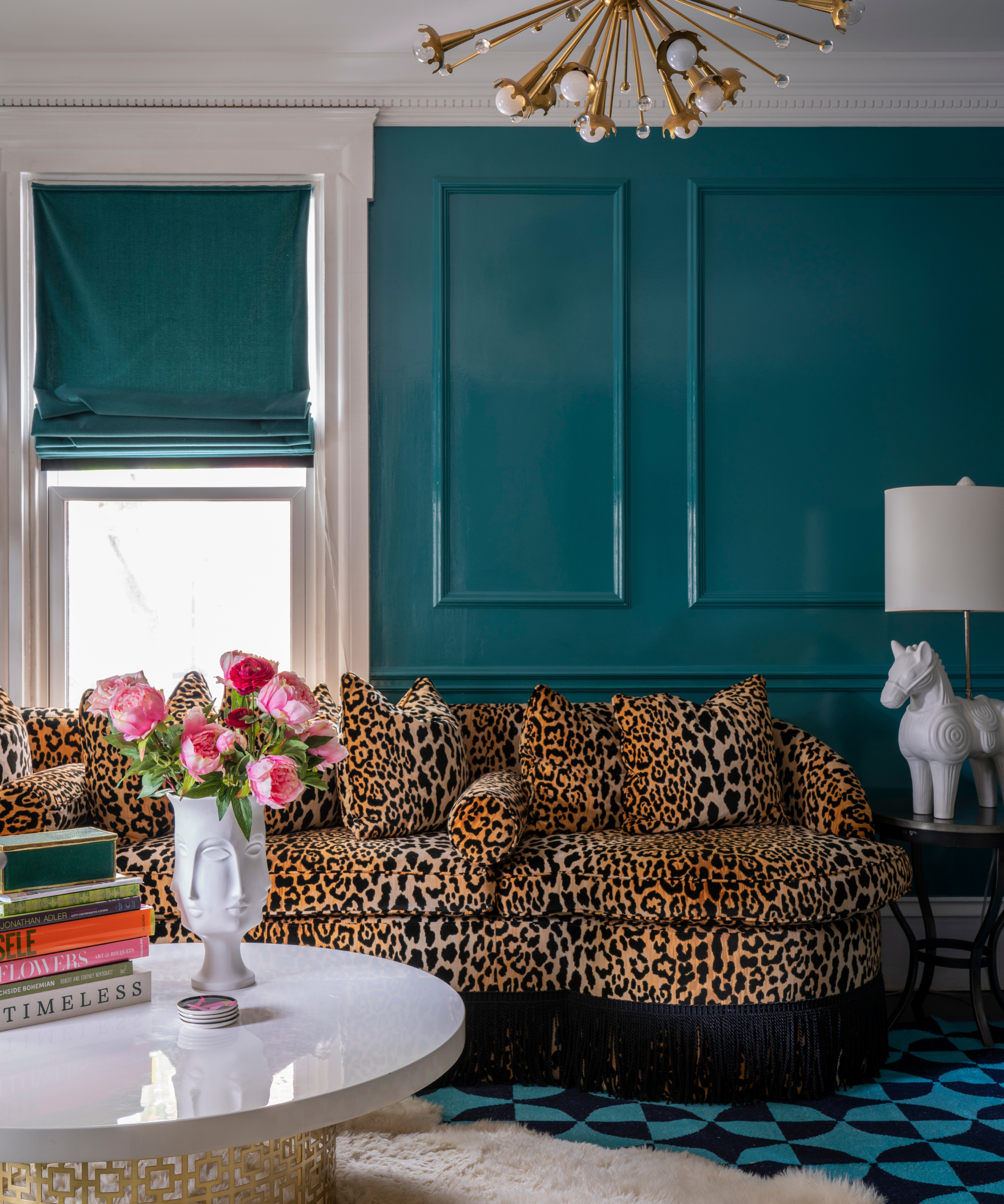 a living room with an animal print couch and glossy blue walls