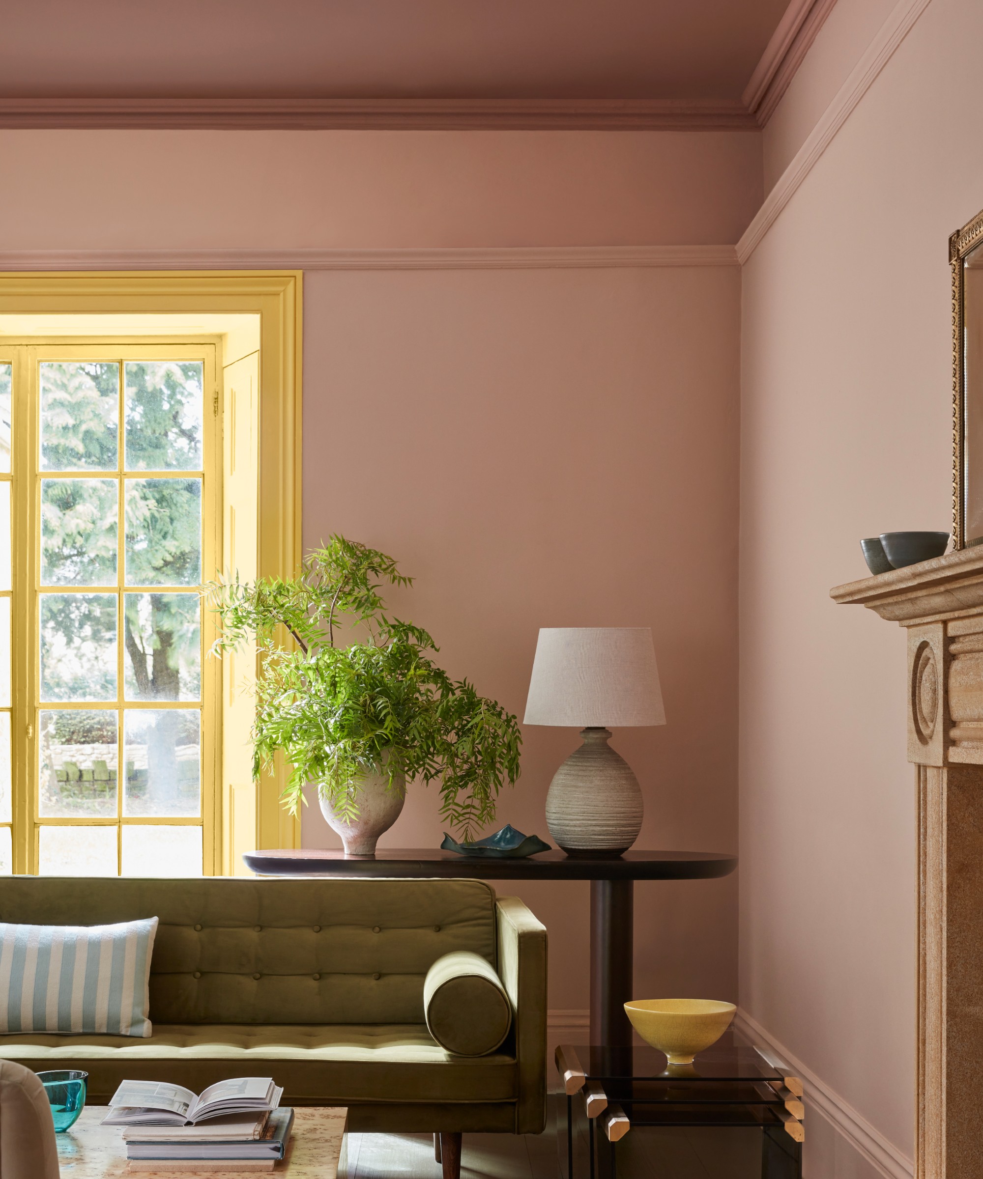 A living room painted in Little Greene's Masquerade pink shade with a darker Blush shade of pink on the ceiling