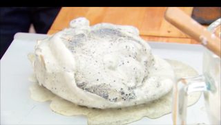A melted mess of ice cream melts off the plate and onto the table