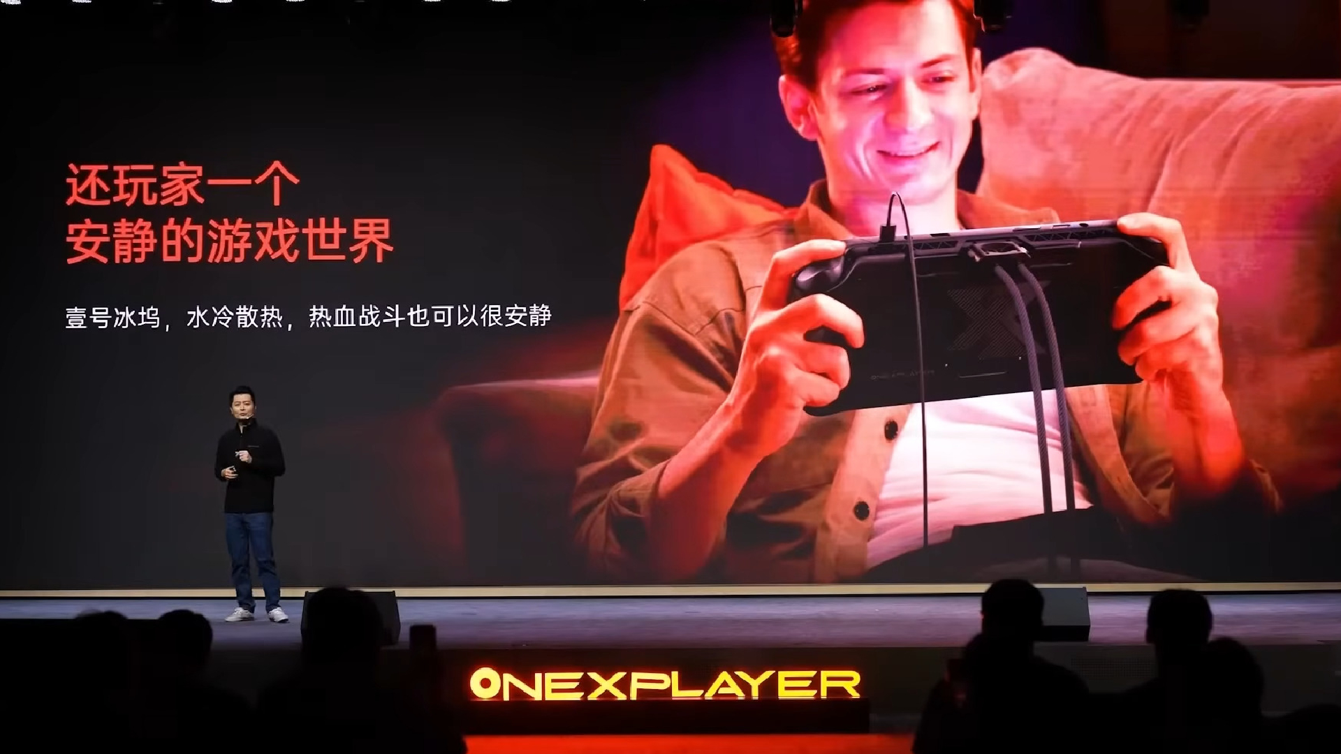 A presentation of the OneXPlayer OneXFly Apex, with a slide behind showing someone using one with the hoses attached