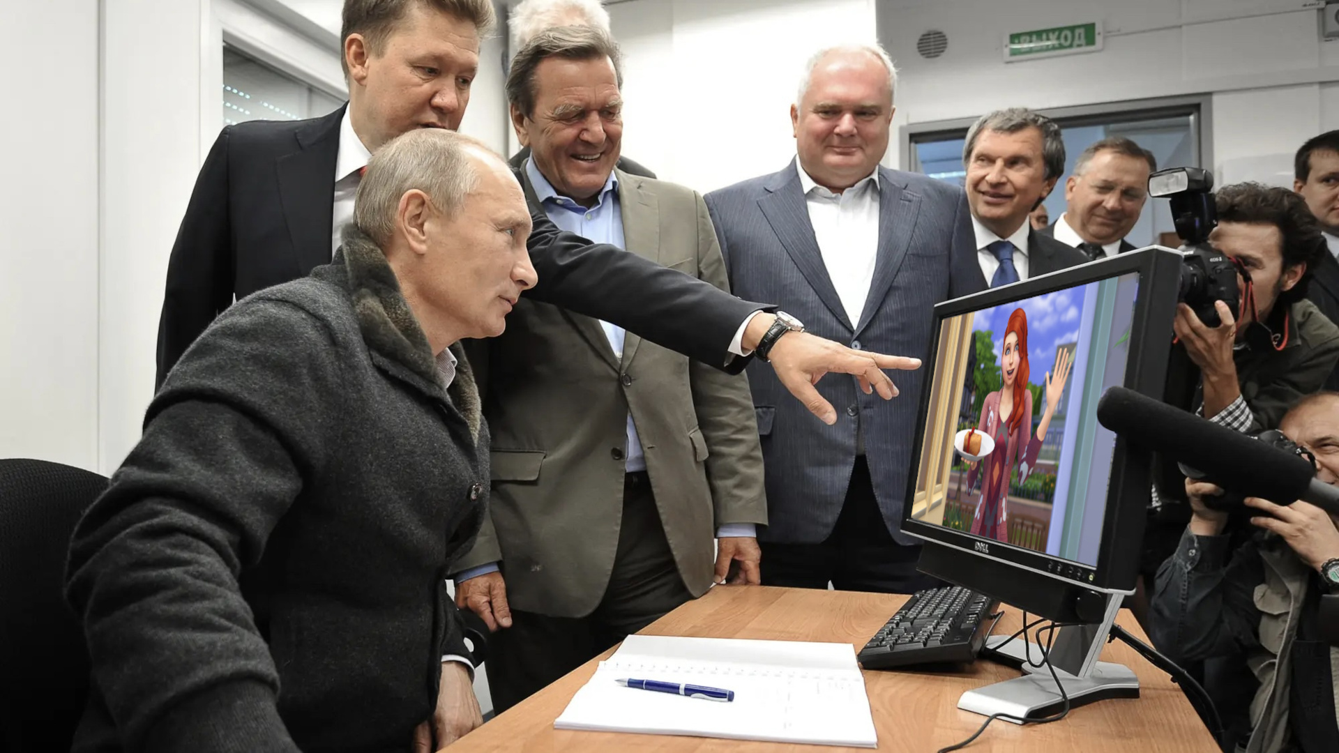 A photo of Vladimir Putin at a computer, onto which a screenshot of a Sim woman bearing a cake has been edited.