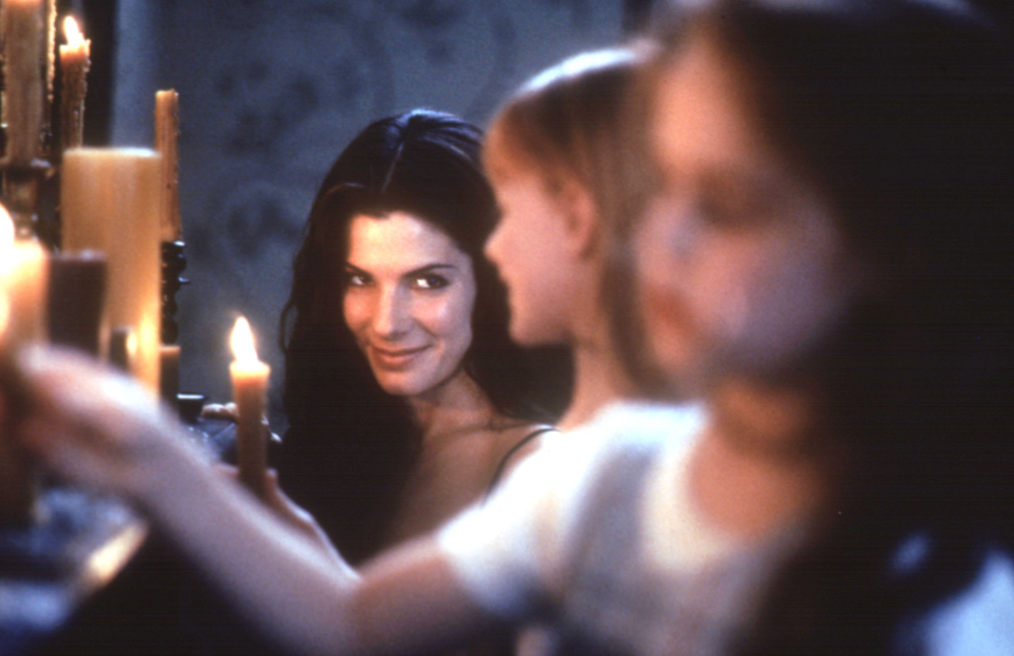 Sandra Bullock smiles and lights a candle in 'Practical Magic