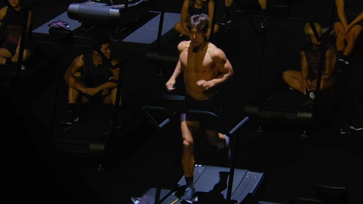 Screenshot of Netflix showing one of the competitors running on a treadmill in Physical: 100 season 2 episode 1.