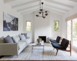 White living room with minimalist furniture and blue couch