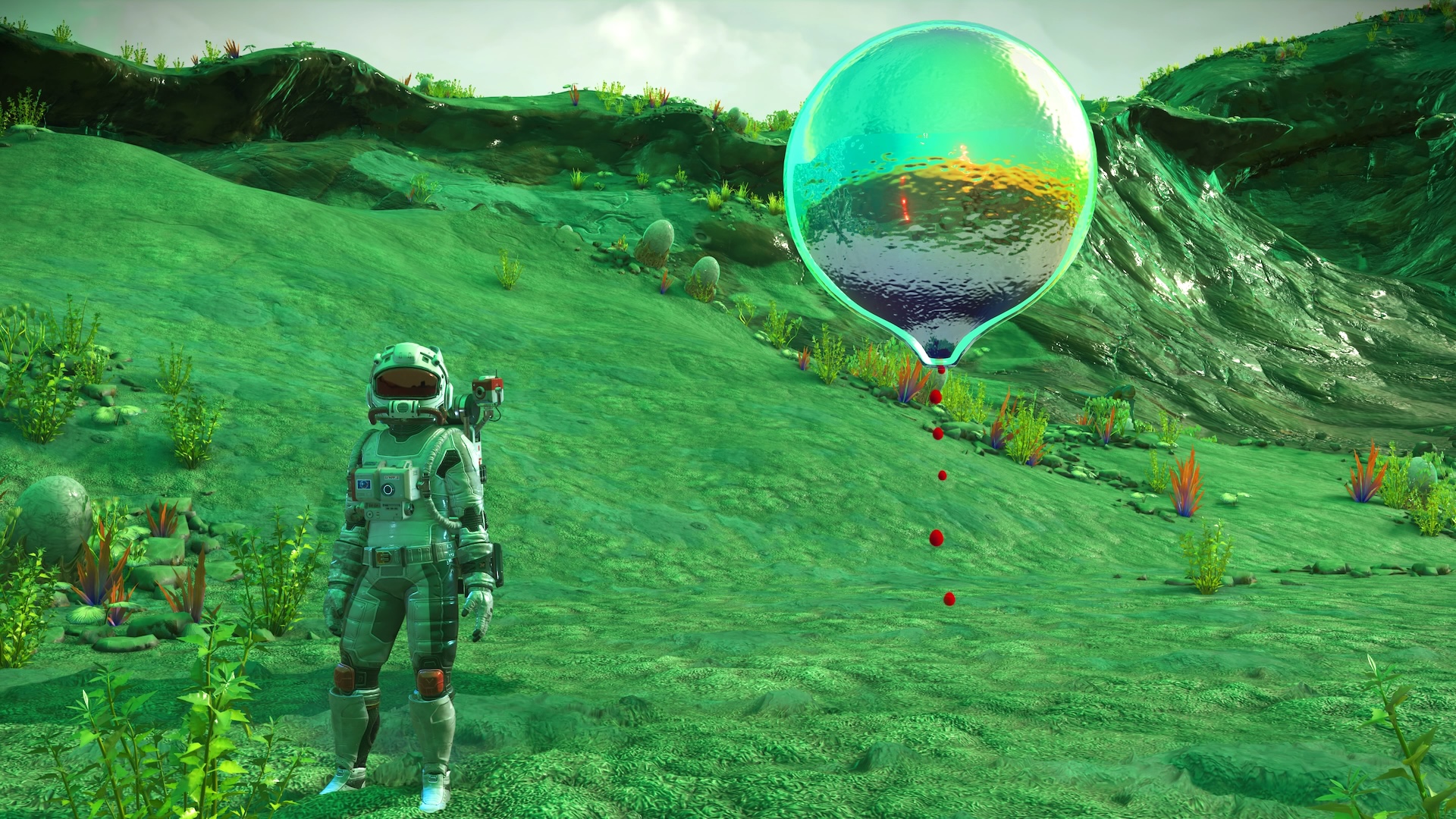 A blood balloon creature floats near a player on a green planet in No Man's Sky: Xeno Arena