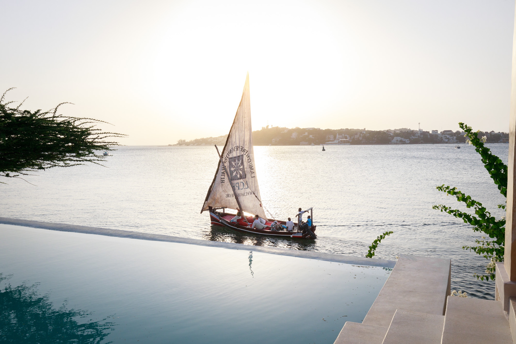 A boat sails past an infinity pool. The view is much nicer than whatever view you have right now.