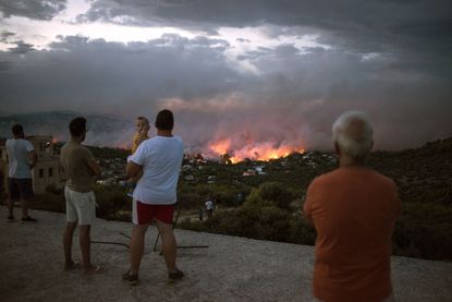 TOPSHOT - EDITORS NOTE: Graphic content / People watch a wildfire in the town of Rafina, near Athens, on July 23, 2018. - At least 20 people have died and more have been injured as wild fires
