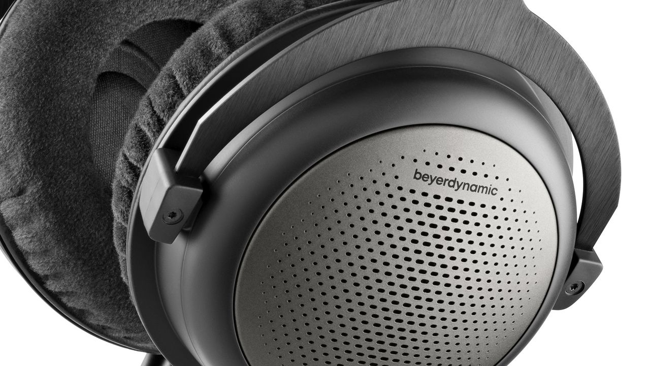 A close-up of the ear cup on a pair of Beyerdynamic T1 (3rd Gen). They are grey and black with fabric cushioning.