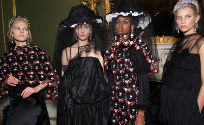 Model wear dresses in black and red floral with veiled hats