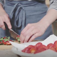 strawberry on plate with chopping board and knife