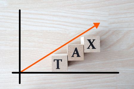 x and y axis with the word tax under a rising arrow