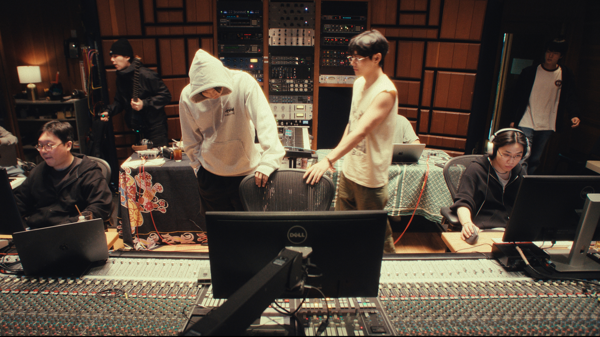 A group of people work in a recording studio, in the Netflix documentary 'BTS: The Return." Pictured, from left: PDogg, Suga, RM, V, unknown, and Jin.
