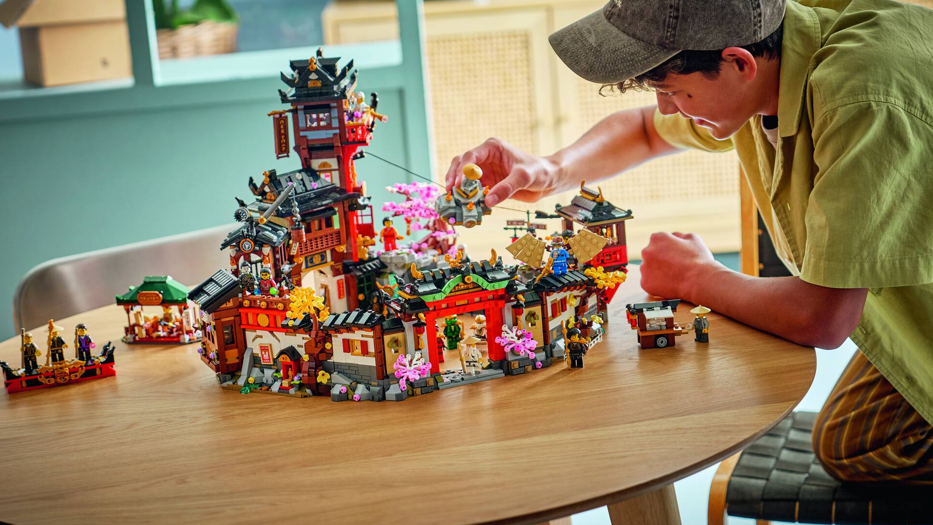 A child plays with the Lego The Old Town set on a wooden table
