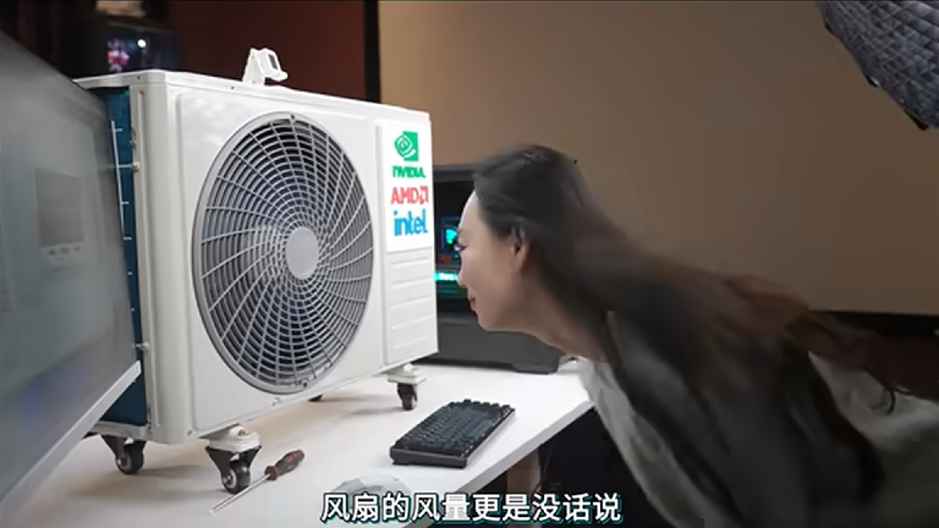 A person putting their head in front of an air conditioning fan attached to a gaming PC.