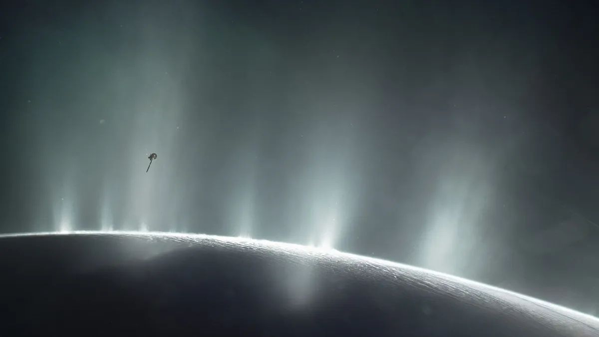 An illustration of NASA&#039;s Cassini orbiter soaring through a giant vapor jet over the moon Enceladus