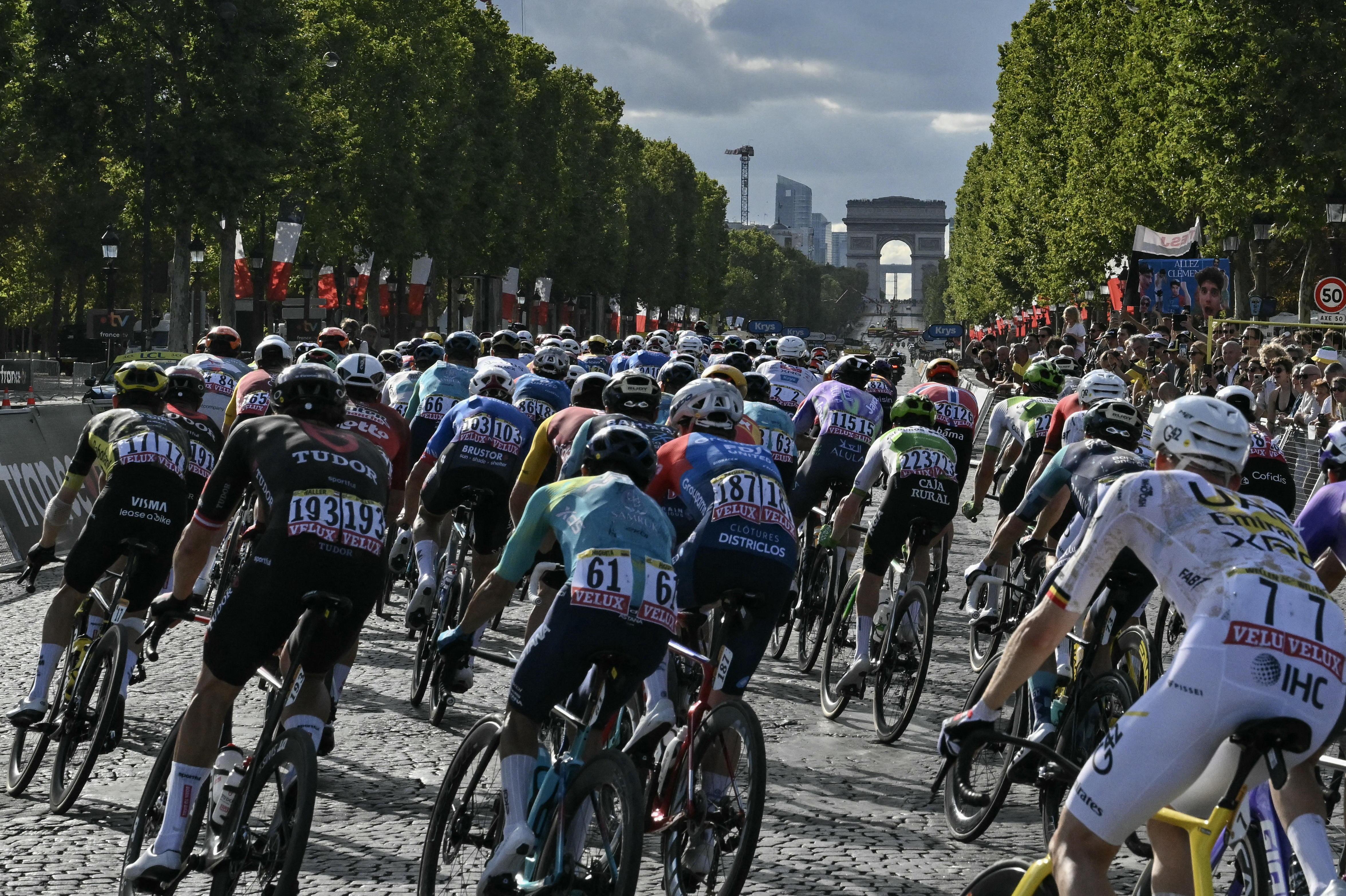The pack of riders (peloton) cycles on the Avenue des Champs-Elysees during the 21st stage of the 113th edition of the Tour de France cycling race, 88,7 km starting and finishing in Paris, on July 26, 2026. (Photo by Jeff PACHOUD / AFP)