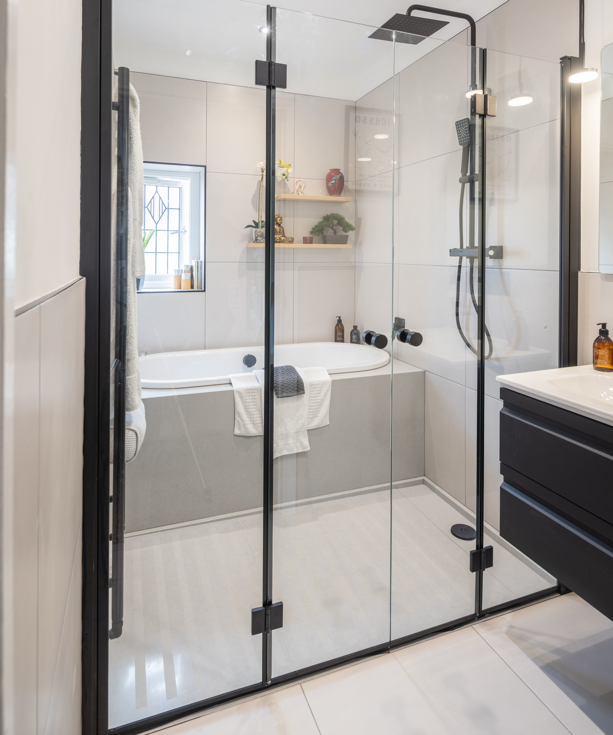 bathroom with shower doors in front of shower and bath