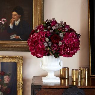 vase with burgundy flower on wooden rack