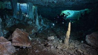 With only a flashlight to light the way, a CINDAQ diver explores the ancient ochre mine. At the end of the last ice age, these caves were dry, but would have been devoid of any natural light.