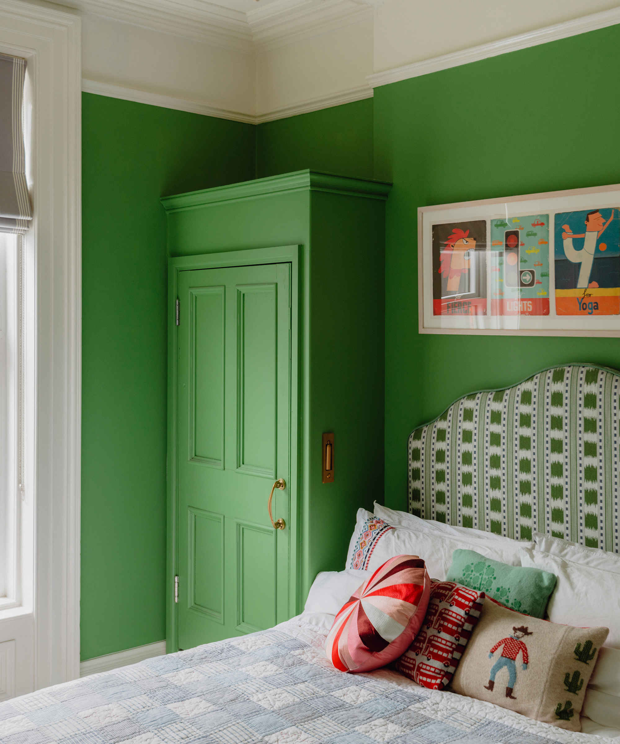 Bold green painted bedroom with patterned headboard