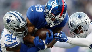 Kenny Golladay #19 of the New York Giants catches the ball and is tackled by Anthony Brown #30 of the Dallas Cowboys during the fourth quarter at MetLife Stadium on December 19, 2021 in East Rutherford, New Jersey.