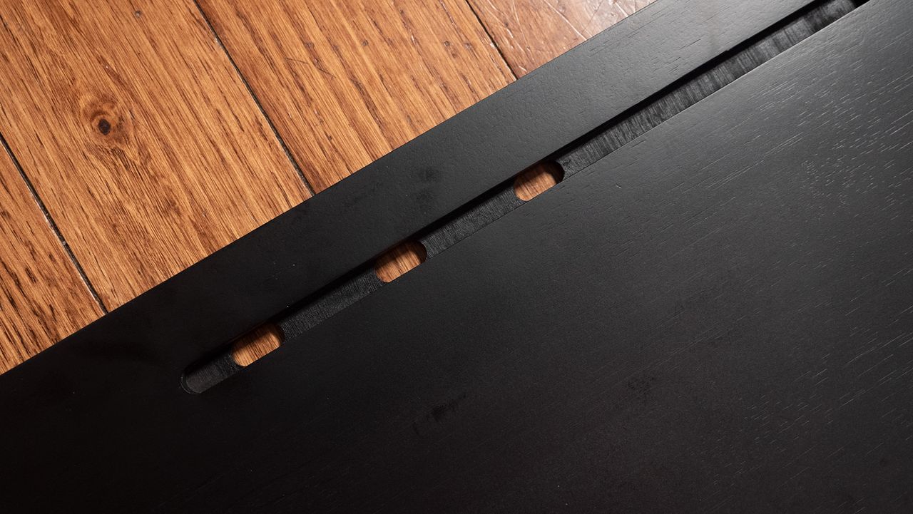 Cord holes for your smartphone or tablet on the Couchmaster Cyboss couch desk