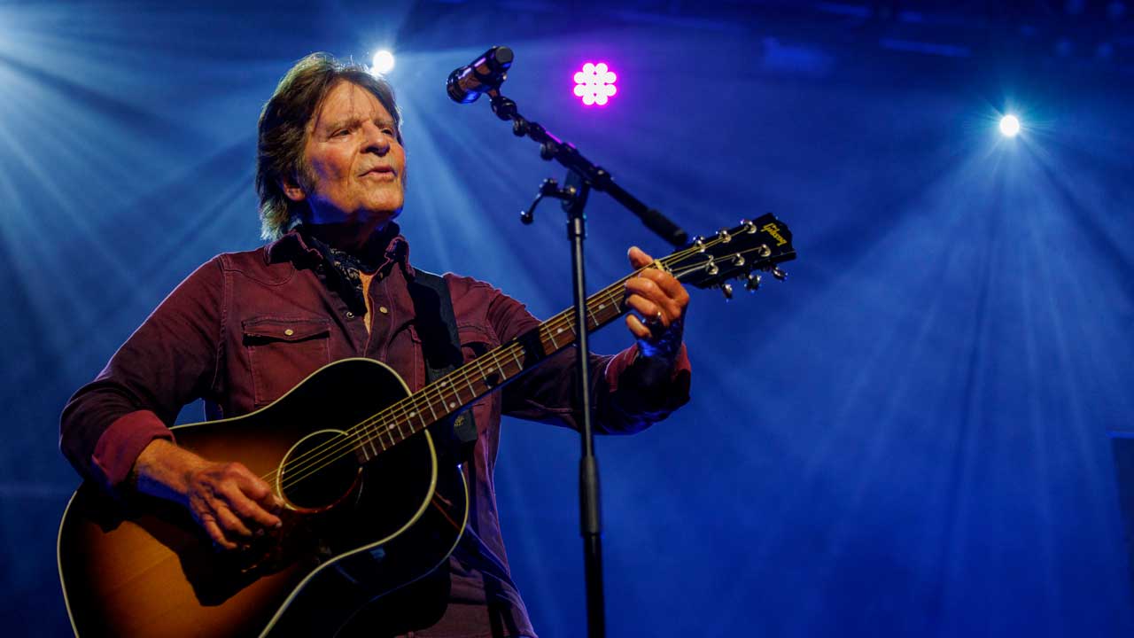 John Fogerty onstage with an acoustic guitar at EarTH in Hackney, East London