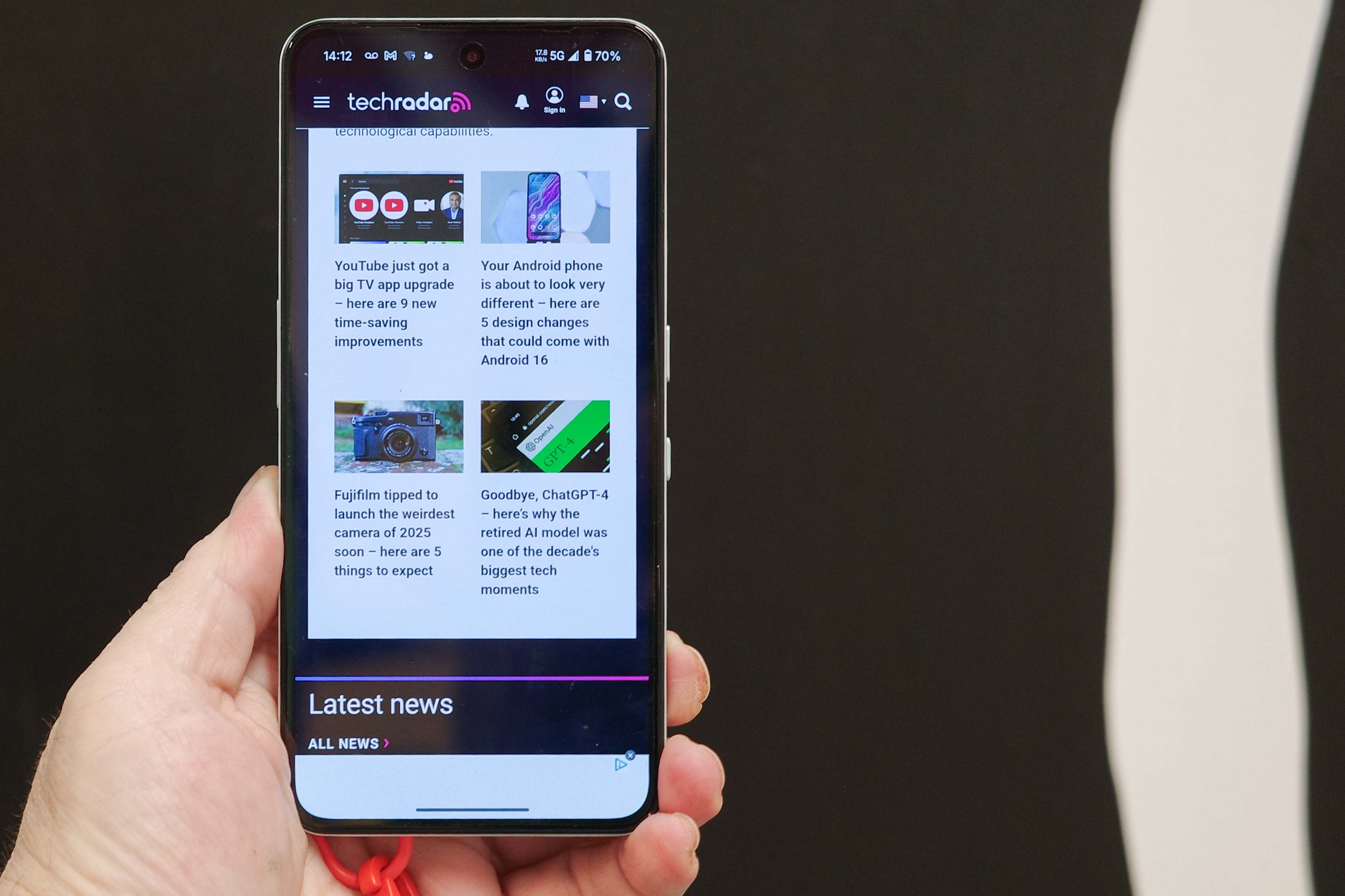 CMF Phone 2 Pro in hand with TechRadar website on screen