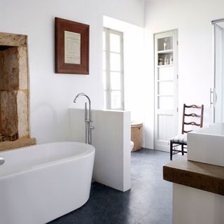 bathroom with white wall and bathtub and white door
