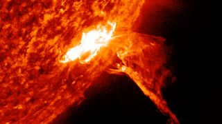 the solar flare appears as a large fiery filament hurled out from the sun. 