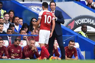 Arsenal's Spanish head coach Unai Emery (R) gestures to Arsenal's German midfielder Mesut Ozil as he is substituted during the English Premier League football match between Chelsea and Arsenal at Stamford Bridge in London on August 18, 2018.