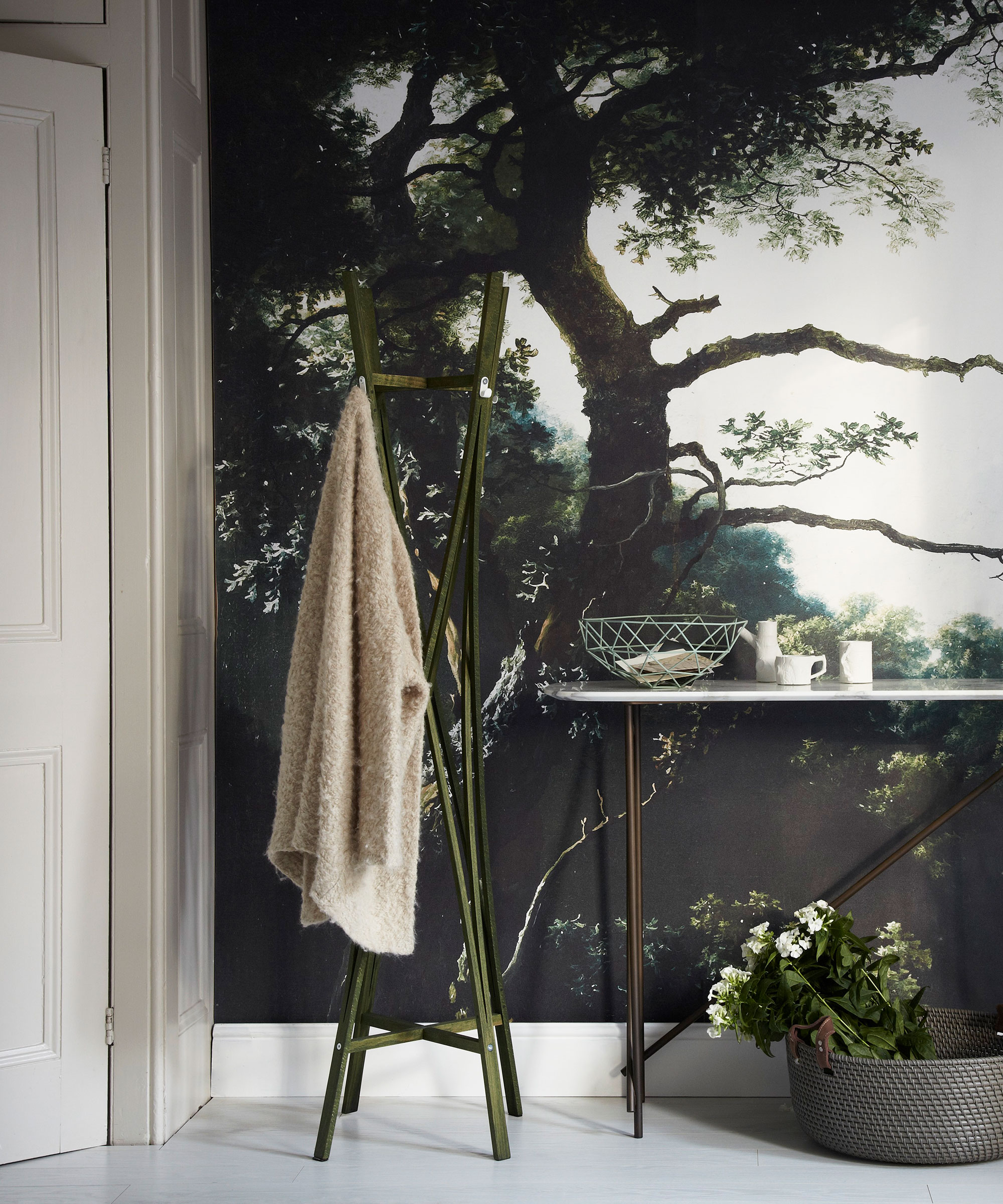 Bedroom accent wall ideas with a green and white forest painted mural, white skirting board and slim metal console table.