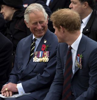 King Charles and Prince Harry look at one another and laugh