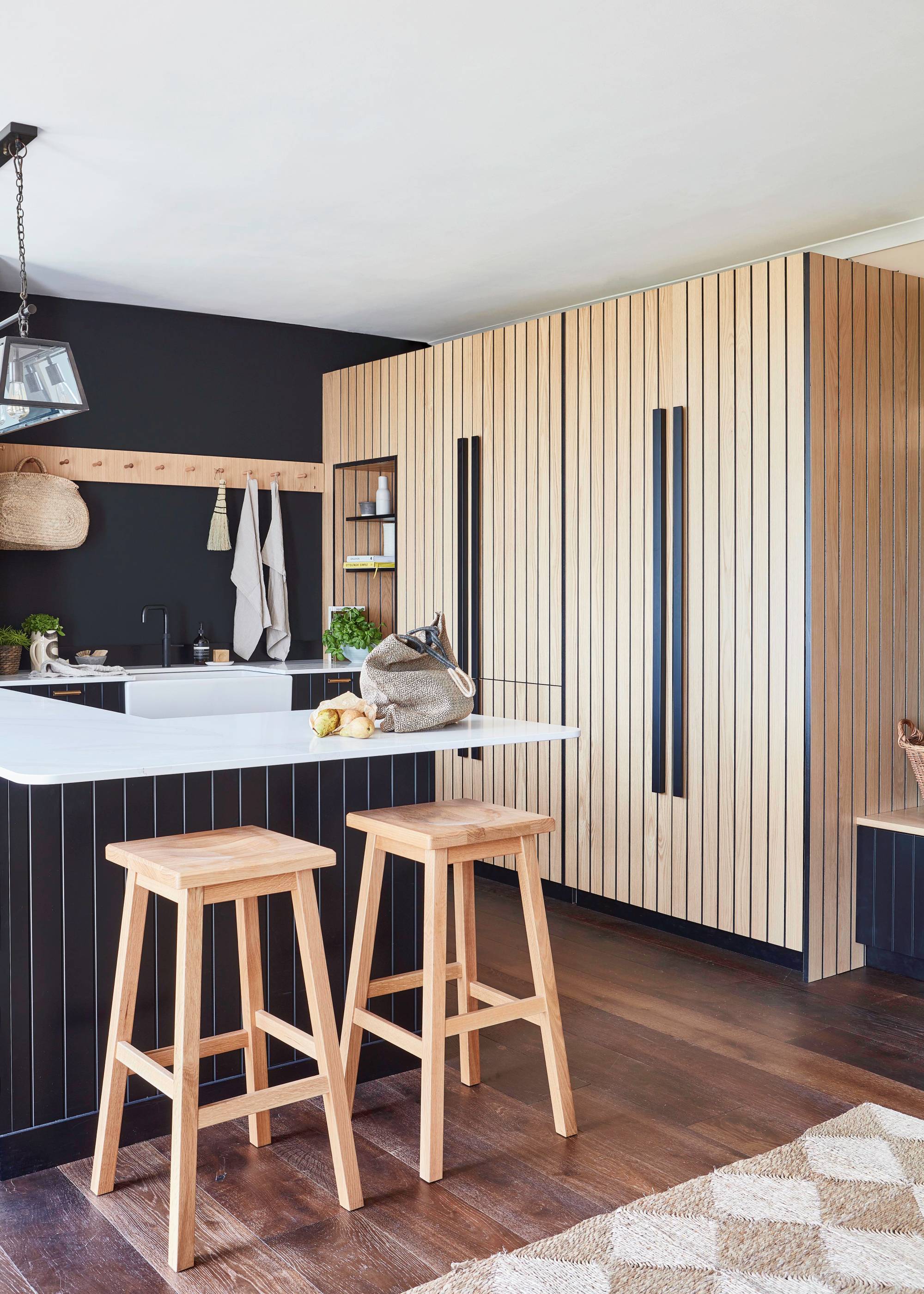 black kitchen island with induction hob in wooden kitchen