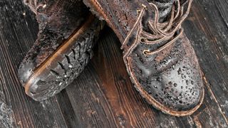 A pair of leather hiking boots with water droplets on them