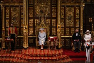 Queen Elizabeth II delivers the Queen's Speech in the House of Lord's Chamber with Prince Charles, Prince of Wales and Camilla, Duchess of Cornwall seated (R) during the State Opening of Parliament at the House of Lords on May 11, 2021 in London, England