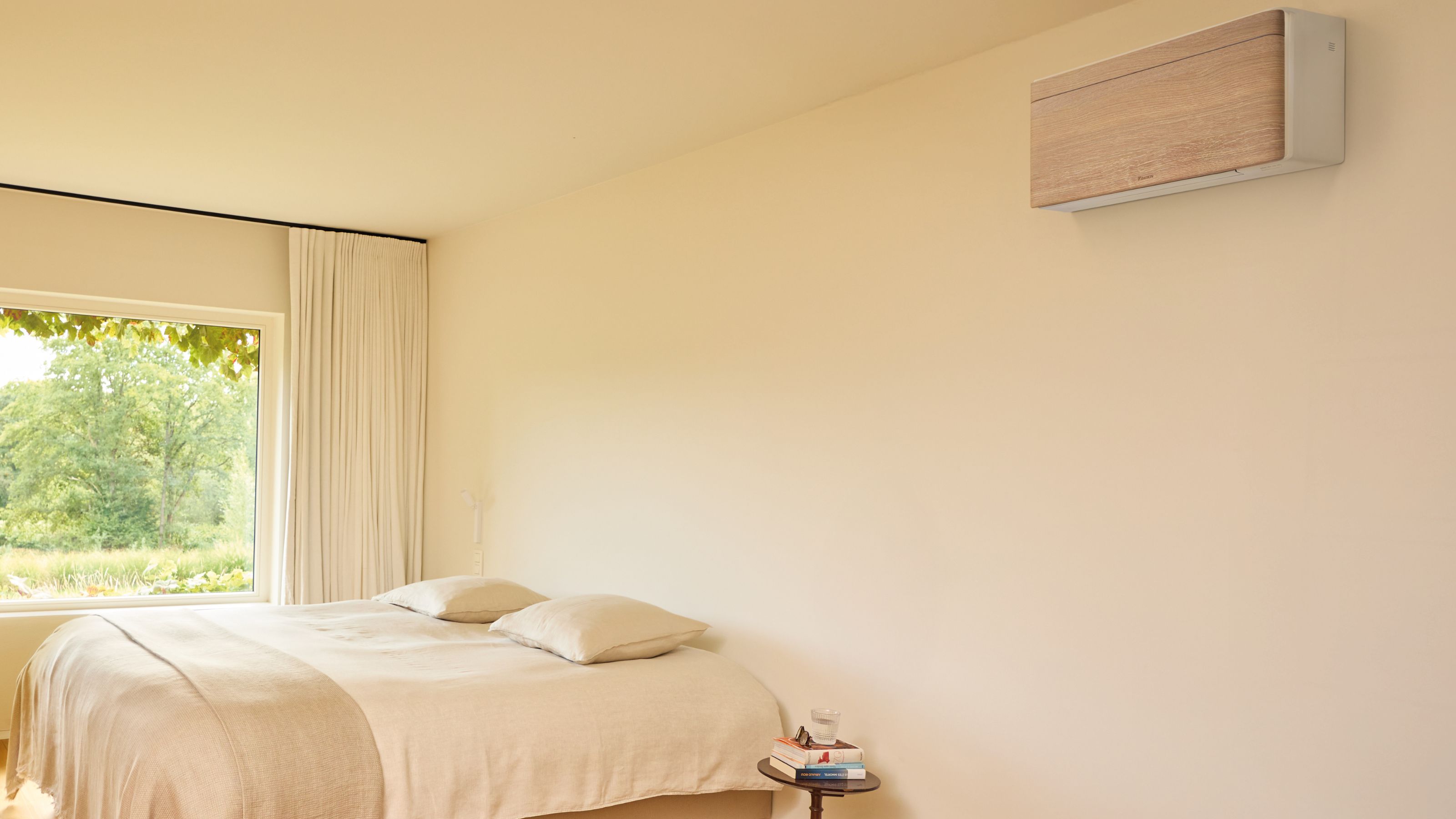 Wood-effect finished air conditioning unit from Daikin's Stylish range, wall-mounted in a neutral bedroom