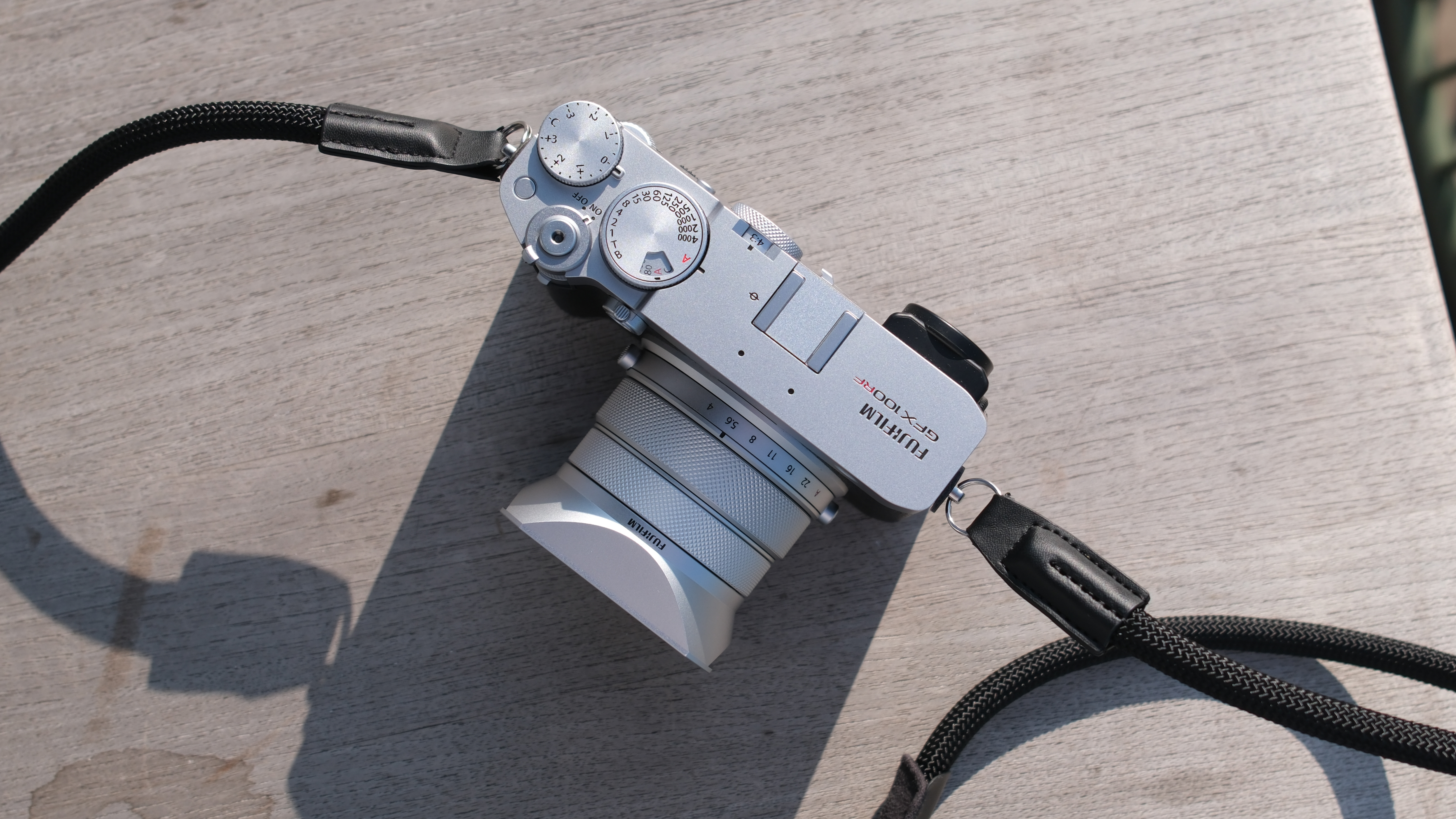 Fujifilm GFX 100RF camera on a wooden table in bright sunlight