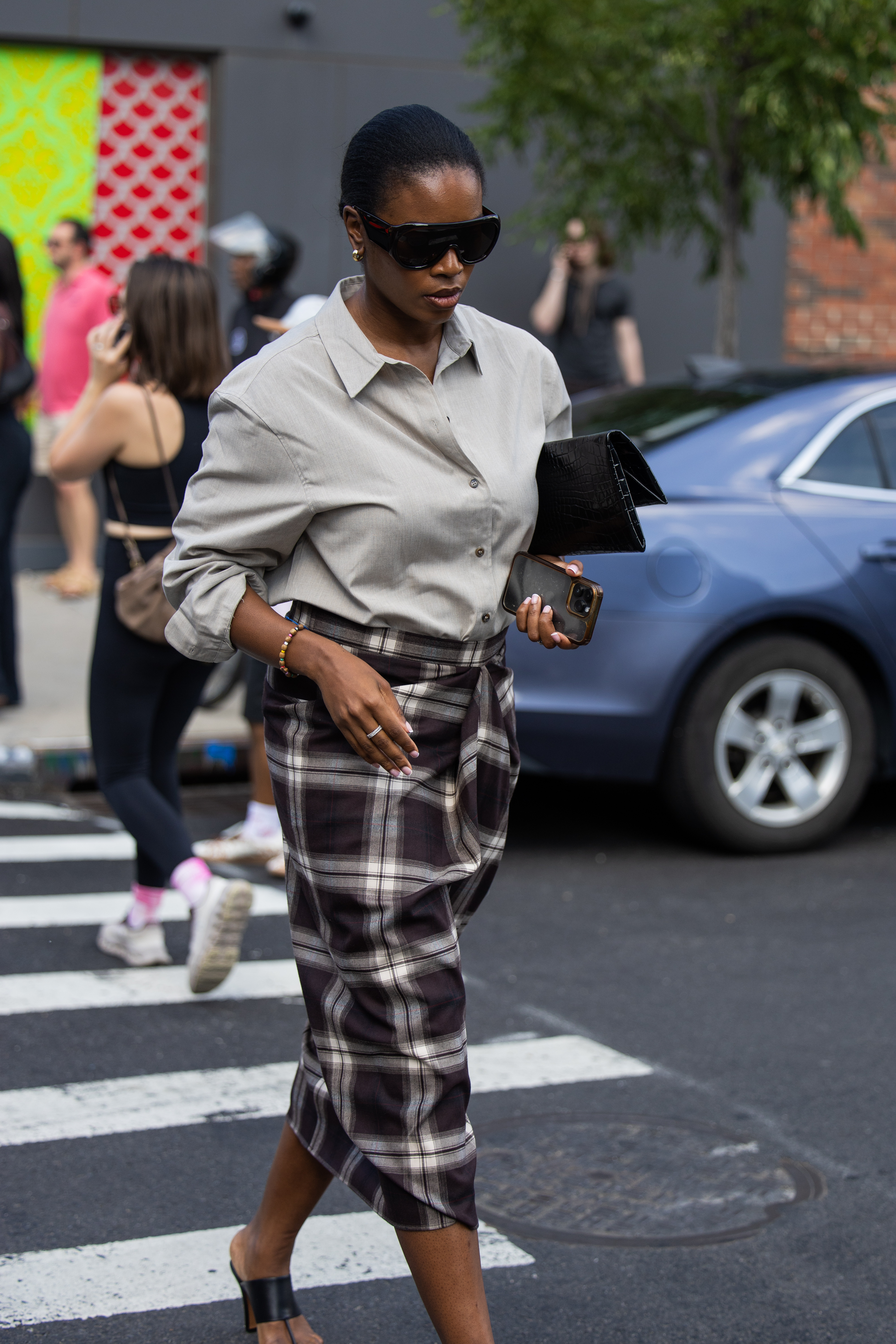 NEW YORK, NEW YORK - SEPTEMBER 14: A guest wears checkered skirt, grey blouse outside Cos during New York Fashion Week on September 14, 2025 in New York City. (Photo by Christian Vierig/Getty Images)