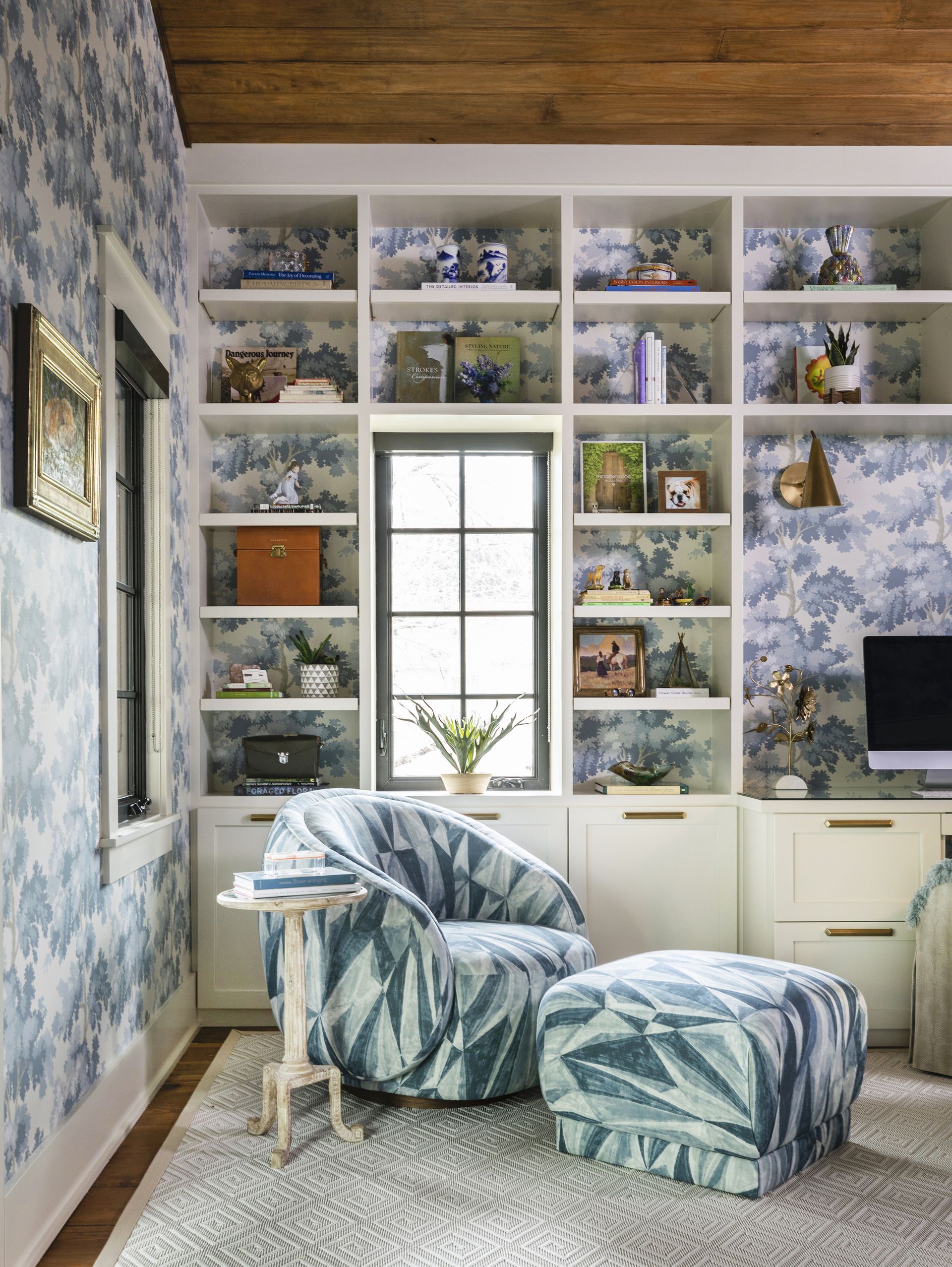 Home office with shelving and cabinets, armchair and footstool and desk just seen
