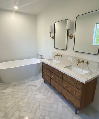 White bathroom with tub and wooden vanity with recycle top