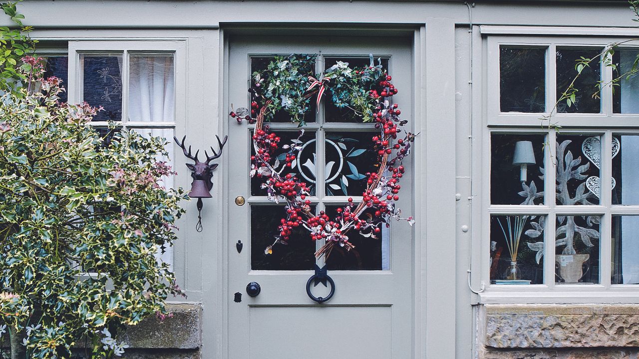 Christmas door with wreath and window decorations.