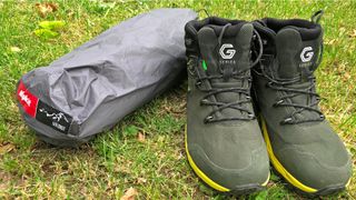 Alpkit Soloist one-person three-season tent packed up with boots for comparison