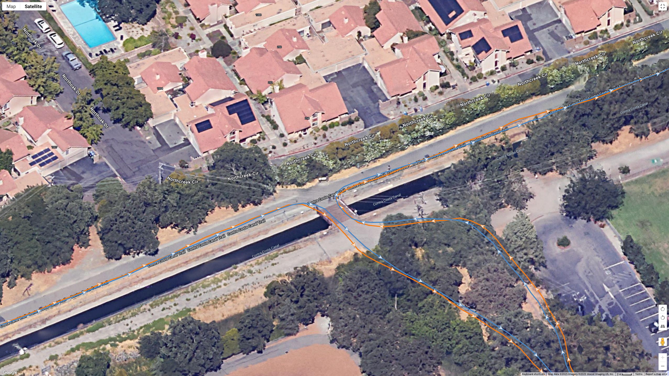 A Google satellite map showing how the Garmin Venu X1's all-systems GNSS line (orange) compares to the Garmin Forerunner 970's dual-frequency GPS line (blue) for accuracy during a city run.