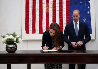 Britain's Prince William, Duke of Cambridge (R) looks on as Catherine, Duchess of Cambridge (L) signs a book of condolence for Orlando shooting victims at the US Embassy in London on June 14, 2016. US investigators on Tuesday worked to untangle the complicated motive of the "radicalized" gunman behind the massacre at a gay club in Orlando, as reports emerged that he frequented the popular nightspot and used gay dating apps.