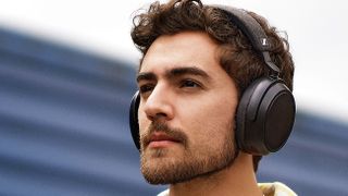 Hero image for best over-ear headphones showing Sennheiser Momentum 4 Wireless PR shot of man outside wearing headphones