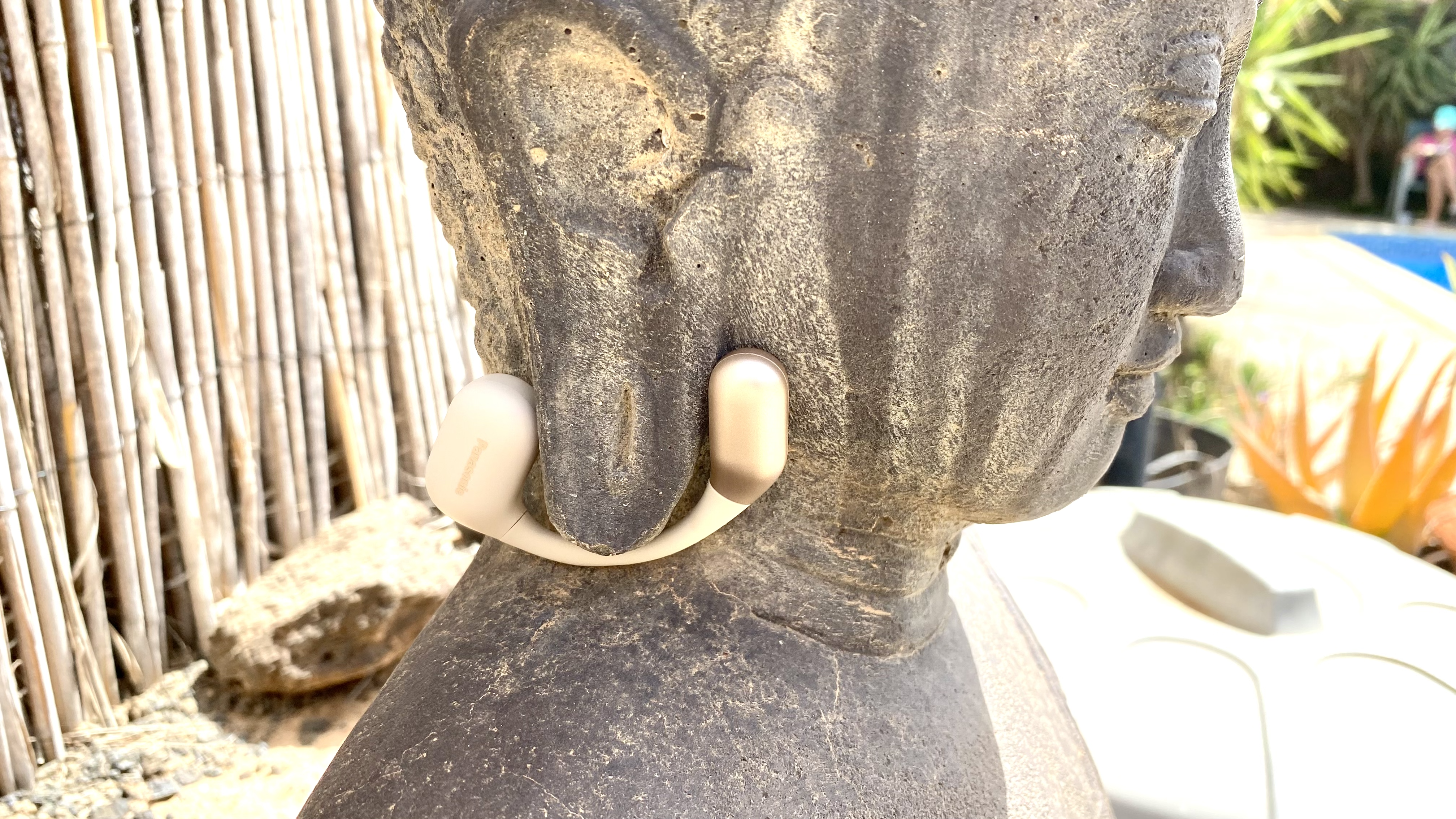 Panasonic RB-F10 open earbuds on a stone pillar