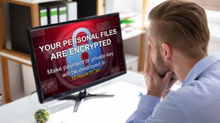 Worried Businessman Looking At Computer With Ransomware Word On The Screen At The Workplace