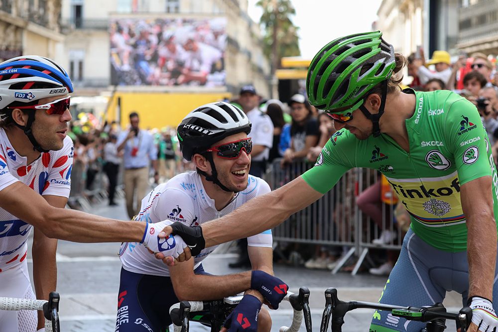 France's Thibaut Pinot (L), wearing the best climber's polka dot jersey, shakes hands with Slovakia's Peter Sagan (R), wearing the best sprinter's green jersey as they wait with England's Adam Yates (C), wearing the best young's white jersey prior to the start the 178 km twelvelth stage of the 103rd edition of the Tour de France