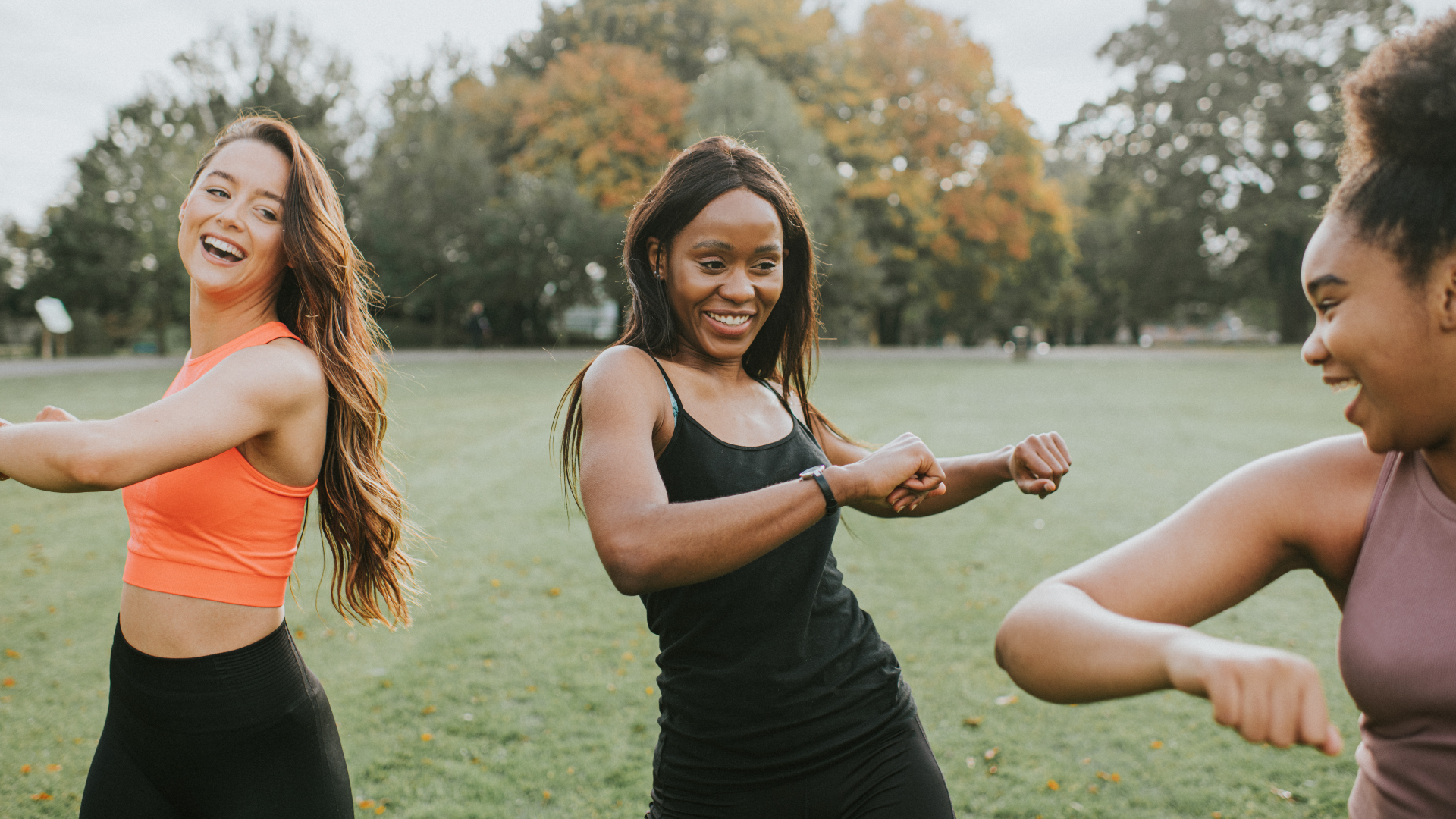 Three women stretching before exercising outdoors